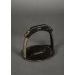 AGED ORIENTAL CAST METAL STIRRUP, cast with stylised dragon mask and with intricate scroll detail to