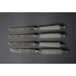 SET OF FOUR FAR EASTERN DESSERT KNIVES, with foliate engraved silver coloured metal blades, carved