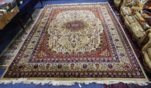 PERSIAN CARPET with circular centre red medallion on an off-white field, with Herati design of large