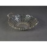 SILVER CIRCULAR TWO-HANDLED DISH, the sides with pierced ovals and dots pattern, also forming the