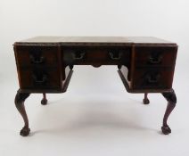 CHIPPENDALE STYLE CARVED MAHOGANY KNEEHOLE DESK, with green leather inlet top, on carved cabriole