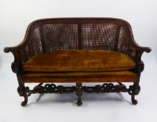 CAROLEAN STYLE CARVED WALNUT BERGÈRE SETTEE with double caned wrap-around back