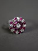 ATTRACTIVE WHITE GOLD/PLATINUM (unmarked) DIAMOND and RUBY SET CLUSTER RING, the central brilliant