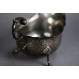 GEORGE V PLANISHED SILVER SAUCE BOAT, of typical form with leaf capped flying scroll handle, cyma