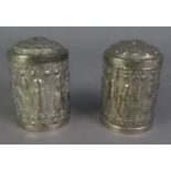 PAIR OF INDIAN EMBOSSED WHITE METAL CYLINDRICAL BOXES AND COVERS, repousse autour with figures and