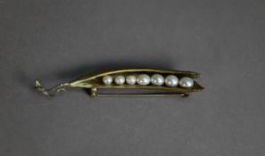 GILT METAL BROOCH in the form of a peapod enclosing seven cultured pearls