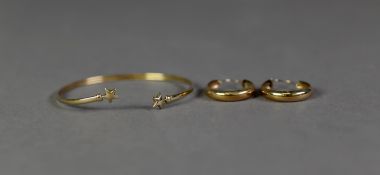 9ct TORQUE BANGLE with star pattern terminals, 2.7gms and a pair of 9ct gold hoop EARRINGS 1.8gms (