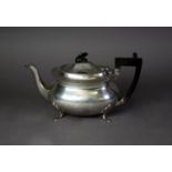 GEORGE V SILVER TEAPOT, of rounded oblong form with black angular scroll handle and knop and pad