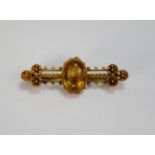 VICTORIAN 15ct GOLD FANCY WING SHAPED BROOCH, collet set with a centre oval citrine, triple bar