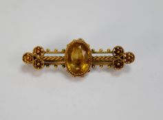 VICTORIAN 15ct GOLD FANCY WING SHAPED BROOCH, collet set with a centre oval citrine, triple bar