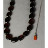 NECKLACE OF DARK BROWN AMBER DISC SHAPED OVAL BEADS, 22? (55.8cm) long (clasp faulty) and a silver