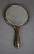 GEORGE V ENGRAVED SILVER BACKED HAND MIRROR, with circular bevel edges plate and moulded wavy