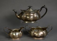 GEORGE V SILVER THREE PIECE TEA SET, oval and embossed with everted wavy edge, the teapot with