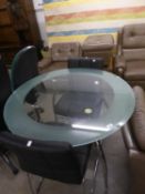 A GLASS TOPPED CIRCULAR KITCHEN TABLE, ON THREE CURVED TUBULAR BRIGHT METAL LEGS AND TWO BLACK