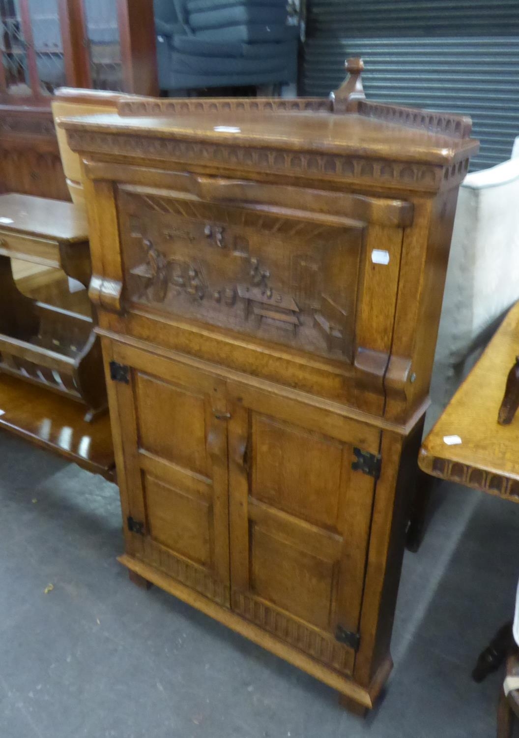 PROFUSELY CARVED OAK CORNER COCKTAIL CABINET WITH FALL-FRONT SECTION OVER CUPBOARD WITH TWO DOORS,