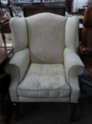 GEORGIAN STYLE WINGED FIRESIDE ARMCHAIR COVERED IN CREAM LEAF EMBOSSED FABRIC, ON MAHOGANY MOULDED