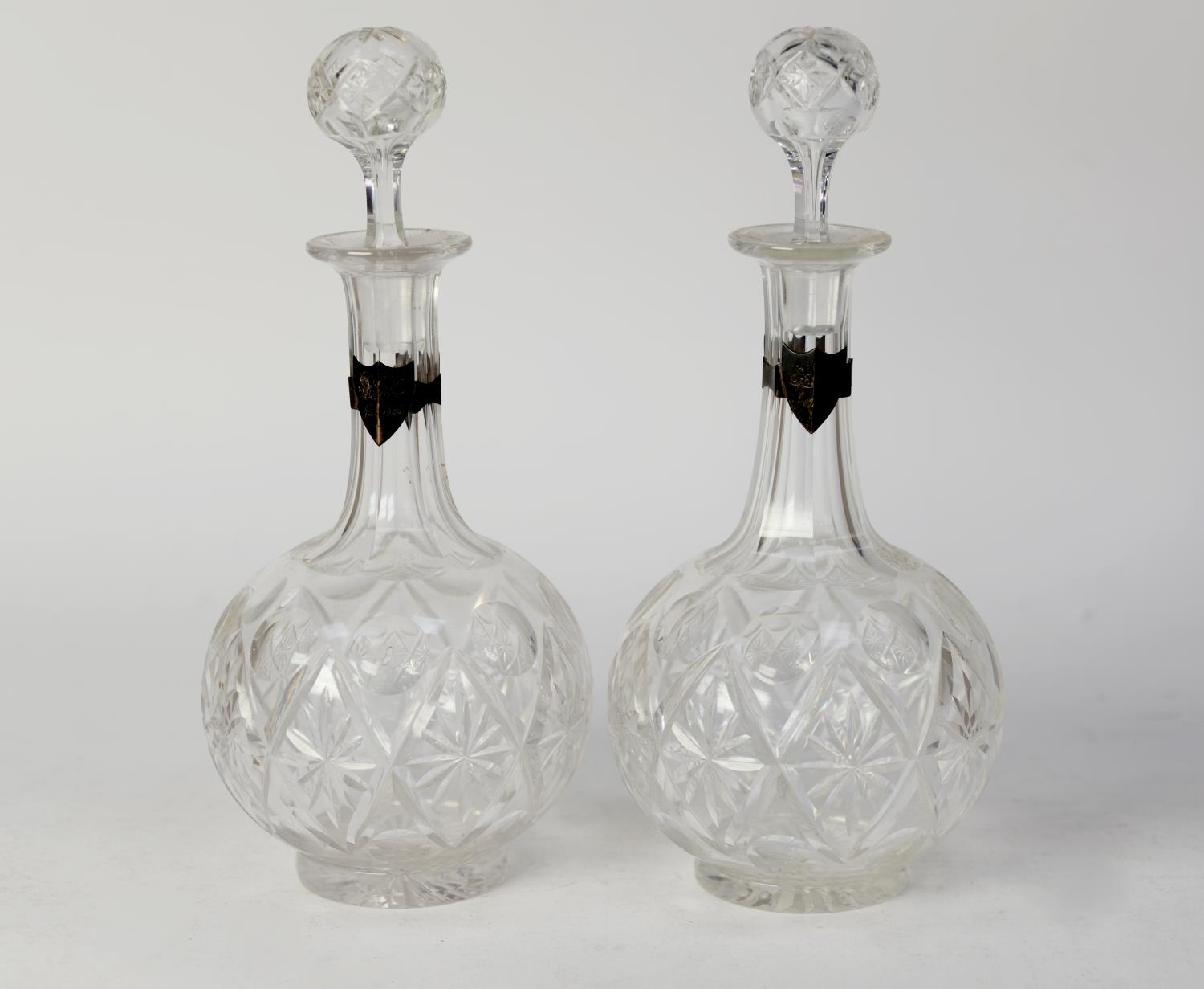 PAIR OF POST WAR CUT GLASS GLOBE AND SHAFT SHAPED DECANTERS AND STOPPERS WITH WHITE METAL SHIELD