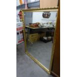 A LARGE OBLONG BEVELLED EDGE WALL MIRROR, IN GILT FRAME