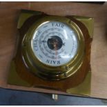 A SHIP?S STYLE BRASS DRUM CASED ANEROID BAROMETER, ON WOODEN BACK PANEL