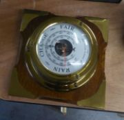 A SHIP?S STYLE BRASS DRUM CASED ANEROID BAROMETER, ON WOODEN BACK PANEL