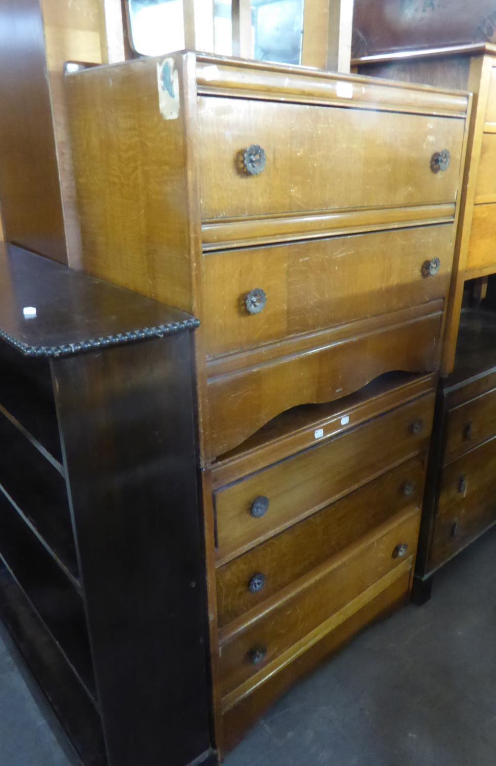 AN OAK CHEST OF  THREE LONG DRAWERS AND A DRESSING CHEST ENSUITE, WITH TWO LONG DRAWERS AND