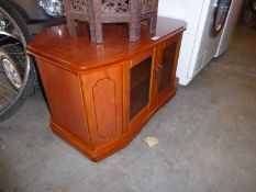A YEW WOOD CORNER TELEVISION STAND, WITH TWO GLAZED BI-FOLD DOORS