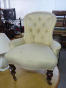 AN ANTIQUE BUTTON BACK NURSING CHAIR, COVERED IN CREAM FABRIC, RAISED ON TURNED FRONT SUPPORTS