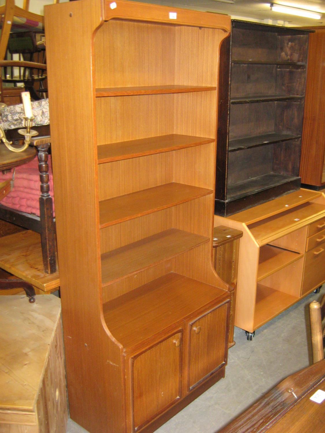 AN OPEN BOOKCASE WITH FOUR SHELVES AND CUPBOARD BASE