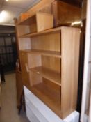 A LIGHT OAK MID-CENTURY, STEP TOPPED FOUR TIER OPEN BOOKCASE, WITH SMALL CUPBOARD TO THE LEFT OF THE
