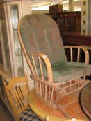 A HARDWOOD ROCKING ARMCHAIR, WITH LOOSE CUSHION BACK AND SEAT