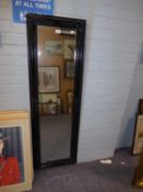 A LARGE RECTANGULAR WALL MIRROR, IN BLACK PAINTED FRAME