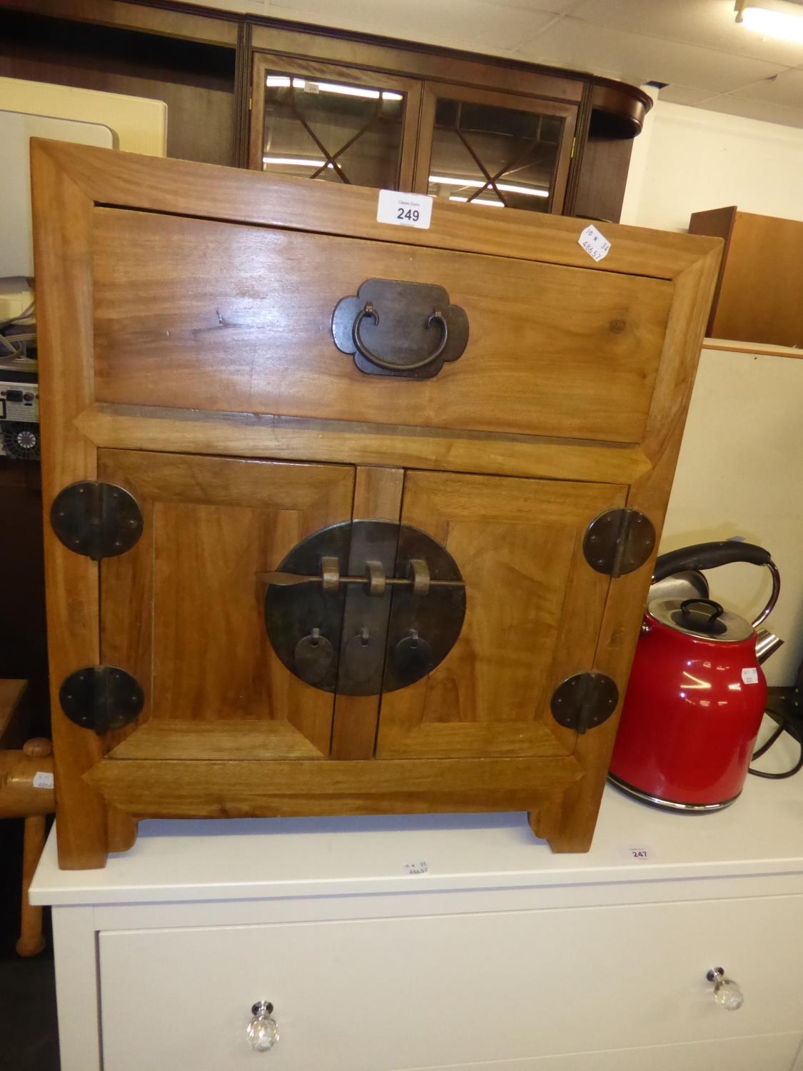 CHINESE HARDWOOD BEDSIDE CUPBOARD WITH TWO DOORS AND A DRAWER ABOVE, WITH HEAVY METAL FITTINGS AND