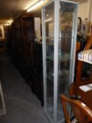 A GREY METAL FRAMED TALL, NARROW DISPLAY CABINET WITH GLASS DOOR AND SIDES, MIRROR BACK, 1’2”