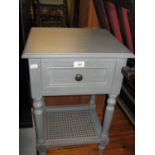A GREY PAINTED WOOD BEDSIDE PEDESTAL WITH DRAWER AND CANE PANEL UNDERSHELF AND A BLOND WOOD SINGLE