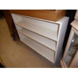 A WHITE PAINTED OPEN BOOKCASE OF THREE TIERS