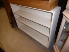 A WHITE PAINTED OPEN BOOKCASE OF THREE TIERS