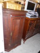 A CARVED OAK ANTIQUE CORNER CUPBOARD