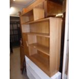 A LIGHT OAK MID-CENTURY, STEP TOPPED FOUR TIER OPEN BOOKCASE, WITH SMALL CUPBOARD TO THE LEFT OF THE