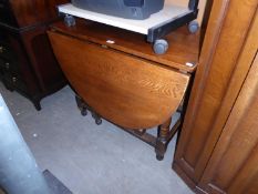 AN OAK OVAL GATELEG DINING TABLE, ON TURNED BALUSTER SUPPORTS, WITH PLAIN STRETCHERS, 5’ X 3’