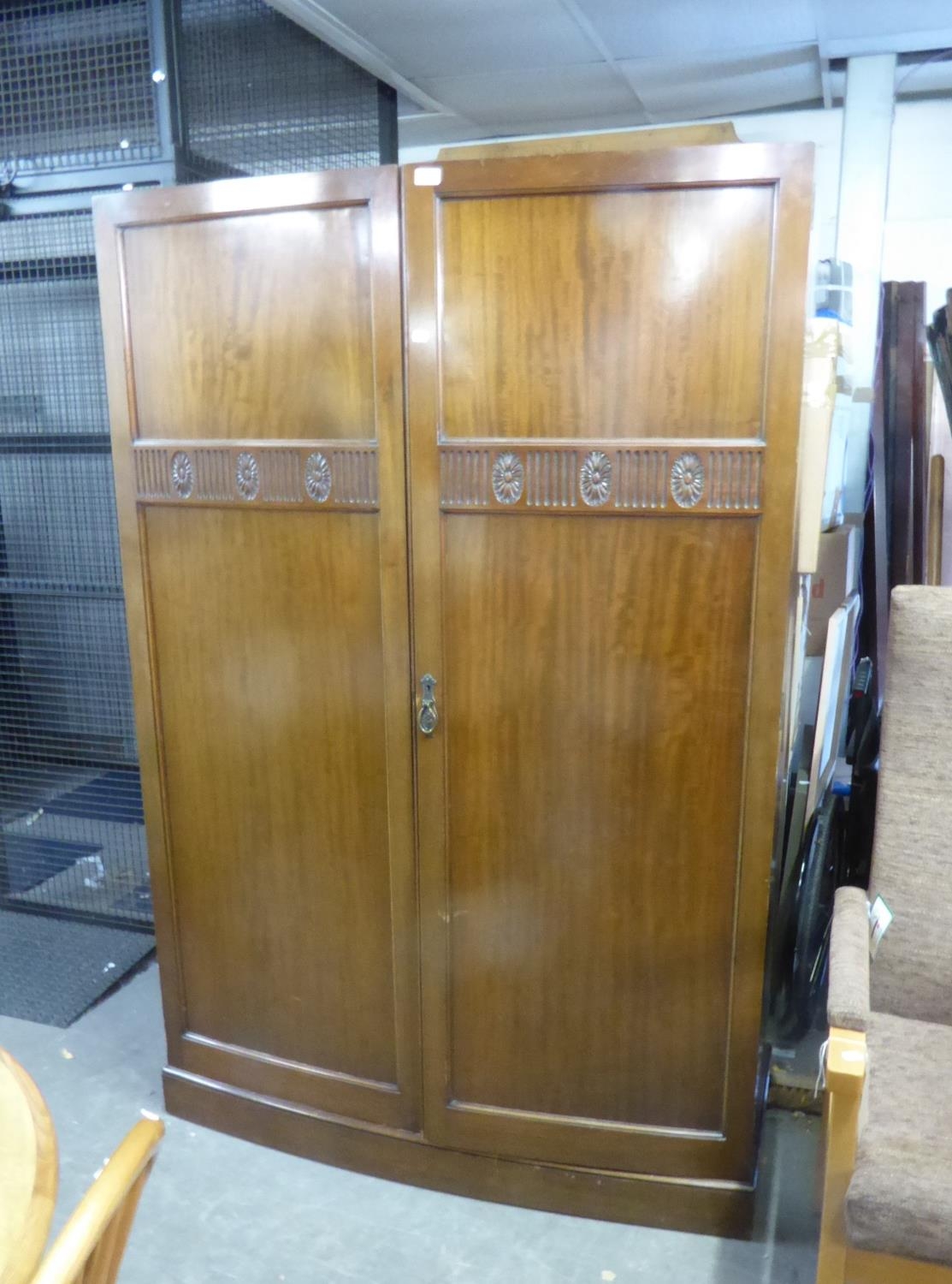 WARING & GILLOW CARVED MAHOGANY WARDROBE WITH SLIGHTLY BOWED FRONT ENCLOSED BY TWO DOORS, 4’ WIDE (