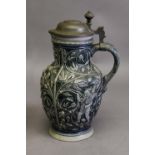 LATE 19th CENTURY GERMAN WESTERWALD STONEWARE BEER JUG with hinged pewter cover, moulded in low