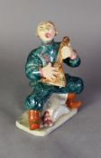 GOLDSCHEIDER WITH MYOTTS POTTERY COMICAL COSSACK SEATED FIGURE, playing the balalaika, in green