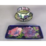 MOORCROFT POTTERY TEACUP AND SAUCER with tube lined radiating decoration of purple formal flowers
