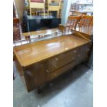 WRIGHTON 1960S TEAK DRESSING TABLE WITH FRAMELESS MIRROR, THREE CENTRE DRAWERS AND END CUPBOARDS, ON