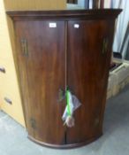 A MAHOGANY ANTIQUE BOW FRONTED CORNER CABINET, WITH 'H' HINGES (LACKING ONE SHELF) 106cm high