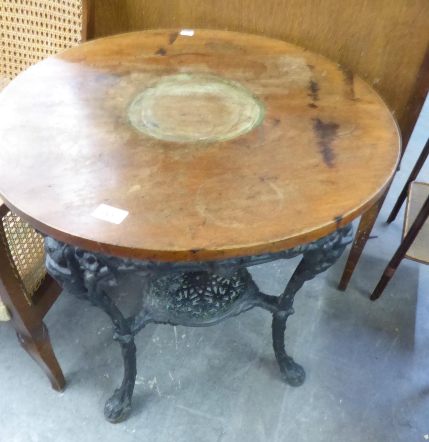 A CAST IRON BRITANNIA PUB TABLE, WITH CIRCULAR WOODEN TOP (TOP CRACKED) 75.5cm high X 62cm diameter