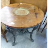 A CAST IRON BRITANNIA PUB TABLE, WITH CIRCULAR WOODEN TOP (TOP CRACKED) 75.5cm high X 62cm diameter
