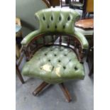 A CAPTAIN'S CHAIR, COVERED IN GREEN LEATHER (WORN AND TORN) ON A FIVE SPUR BASE