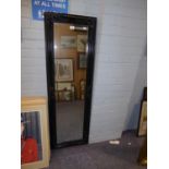 A LARGE RECTANGULAR WALL MIRROR, IN BLACK PAINTED FRAME