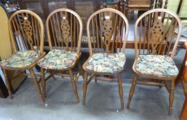 A SET OF FOUR HARDWOOD HOOP BACK DINING CHAIRS, WITH WHEEL SPLATS, PANEL SEATS WITH SQUAB CUSHIONS